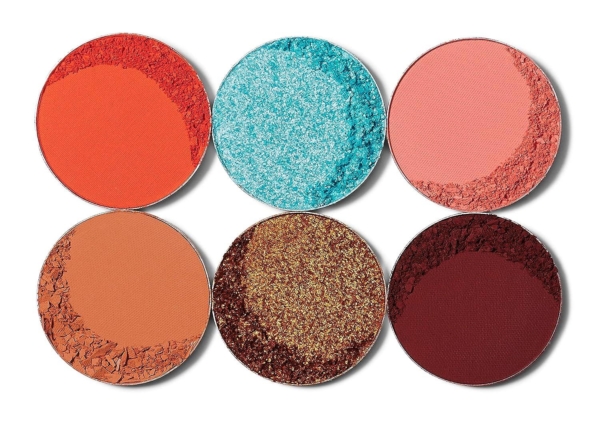 La Palette de Fards à Paupières Olori III 6 Ombres de Juvias Place présente six nuances rondes - rouge, bleu vif chatoyant, rose clair, beige, doré chatoyant et bordeaux foncé - sur deux rangées ; certaines palettes sont lisses tandis que d'autres semblent poudreuses ou craquelées. Dakar