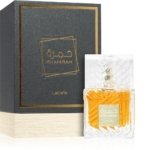Un flacon de Lattafa Khamrah Eau de Parfum mixte 100ml, avec un bouchon texturé transparent et un liquide ambré, se trouve à côté de son coffret noir et or avec des étiquettes en arabe et en anglais. Dakar