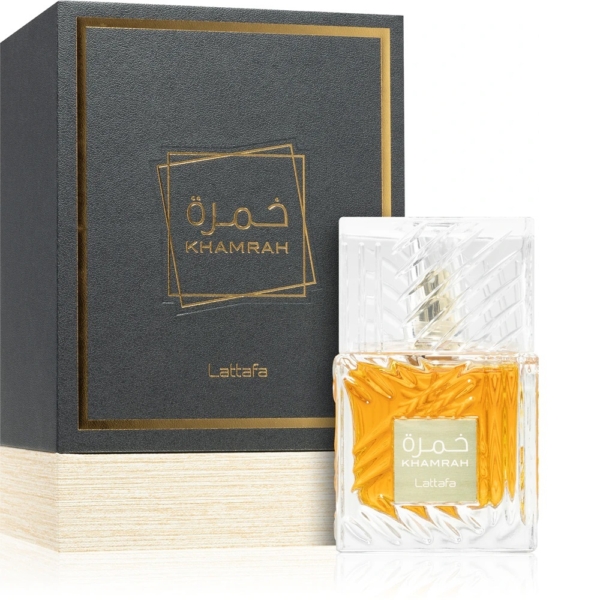 Un flacon de Lattafa Khamrah Eau de Parfum mixte 100ml, avec un bouchon texturé transparent et un liquide ambré, se trouve à côté de son coffret noir et or avec des étiquettes en arabe et en anglais. Dakar