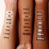 Trois avant-bras aux tons de peau différents présentent 18 échantillons de Nyx Anti Cernes Correcteur Longue Tenue Can't Stop Won't Stop 3,50 ml, étiquetés de « Pale » à « Deep Espresso », montrant un dégradé de nuances pour différents teints. Dakar