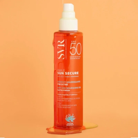 Un flacon de Svr Sun Secure Huile SPF50 Protection Solaire Format Huile non Grasse 200 ml se dresse debout sur une surface orange avec de l'huile renversée à sa base, sur un fond orange vif. Dakar
