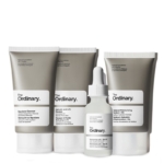 Trois produits de soin gris et blancs de The Ordinary The Balance Set Coffret Clarifiant Peaux à Imperfections — un nettoyant, une crème hydratante et un flacon compte-gouttes — sont exposés, chacun étiqueté avec les noms des produits et les ingrédients. Dakar