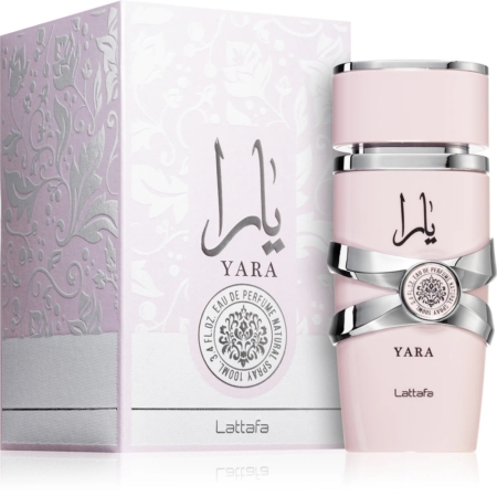 Un flacon rose pâle de Lattafa Yara Eau de Parfum pour femme 100 ml avec des accents argentés se trouve à côté de sa boîte décorative assortie, toutes deux comportant le logo Yara en arabe et en anglais ainsi que des motifs floraux complexes et des détails de marque. Dakar