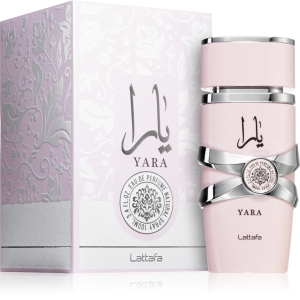 Un flacon rose pâle de Lattafa Yara Eau de Parfum pour femme 100 ml avec des accents argentés se trouve à côté de sa boîte décorative assortie, toutes deux comportant le logo Yara en arabe et en anglais ainsi que des motifs floraux complexes et des détails de marque. Dakar