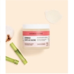 Un pot de Gommage corps au sucre BIO Aroma Zone de 200 g repose sur une surface beige, avec une touche de ce gommage au sucre biologique à proximité. Le bambou et le coton évoquent ses ingrédients naturels, rappelant l'essence pure du Rituel de Sakura de Rituals. Dakar