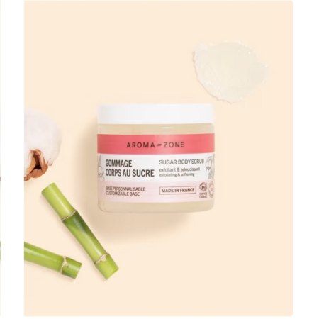 Un pot de Gommage corps au sucre BIO Aroma Zone de 200 g repose sur une surface beige, avec une touche de ce gommage au sucre biologique à proximité. Le bambou et le coton évoquent ses ingrédients naturels, rappelant l'essence pure du Rituel de Sakura de Rituals. Dakar