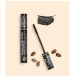 Un tube de Mascara Aroma Zone soin Noir au Ricin BIO 10ml au design botanique, son applicateur baguette, un trait de mascara noir et plusieurs graines de ricin disposées sur un fond beige. Dakar