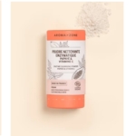 Un récipient cylindrique de 30 g de Poudre nettoyante enzymatique Papaye et Vitamine C d'Aroma Zone se tient debout sur une surface beige, avec un petit tas de poudre saupoudré à proximité. Dakar