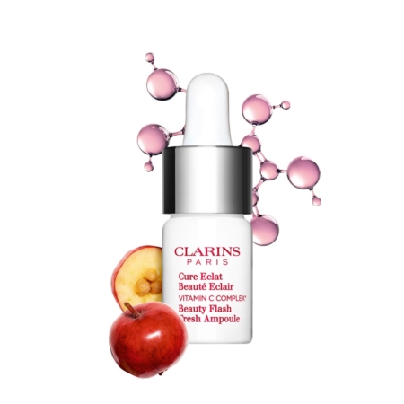 Un flacon blanc de Clarins Cure Eclat Beauté Eclair Fresh Ampoule 8 ml avec un compte-gouttes est représenté à côté de tranches de pommes et de structures moléculaires roses sur un fond blanc. Dakar