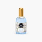 Un flacon en verre transparent de l'Eau de toilette Musc blanc Les Petits Plaisirs 110 ml, rempli d'un liquide bleu et surmonté d'un bouchon doré, se détache élégamment sur un fond blanc uni. L'étiquette est ornée de fleurs blanches. Dakar