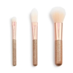 Ensemble de 3 mini-pinceaux MakeUp Revolution. 3 pièces, avec poils blancs, viroles or rose et manches dorés pailletés, sont disposés verticalement sur fond blanc. Chaque pinceau a une taille et une forme différentes. Dakar