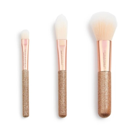 Ensemble de 3 mini-pinceaux MakeUp Revolution. 3 pièces, avec poils blancs, viroles or rose et manches dorés pailletés, sont disposés verticalement sur fond blanc. Chaque pinceau a une taille et une forme différentes. Dakar