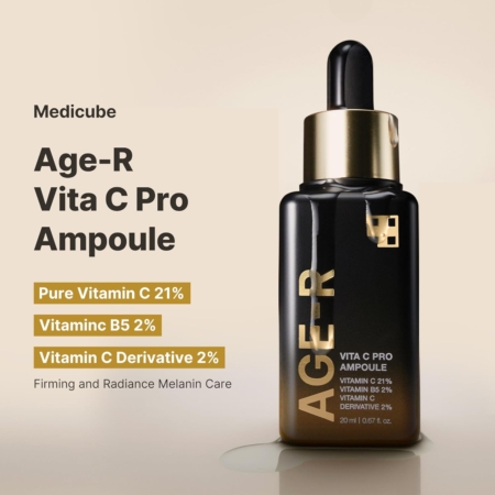 Un flacon compte-gouttes noir et or étiqueté « AGE-R Vita C Pro Ampoule » repose sur une surface claire, avec un texte mettant en évidence la vitamine C pure 21 %, la vitamine B5 2 % et le dérivé de vitamine C 2 % pour le soin de la mélanine. Dakar