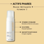 Un flacon blanc de Nuhanciam Mousse Nettoyante VITAMINE C Lissage et Fermeté de la Peau Douce 150 ml repose sur un fond beige, avec un texte mettant en valeur la vitamine C stabilisée, le diglycérol et une base nettoyante douce à base de plantes. Dakar