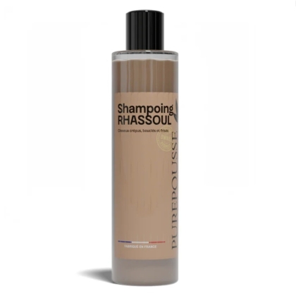 Un flacon de 250 ml de Purepousse Shampoing Rhassoul Anti Pellicules Démangeaisons et Cheveux Secs avec un bouchon noir, un liquide brun et un texte français, conçu pour les cheveux ondulés, bouclés, frisés et crépus. Dakar