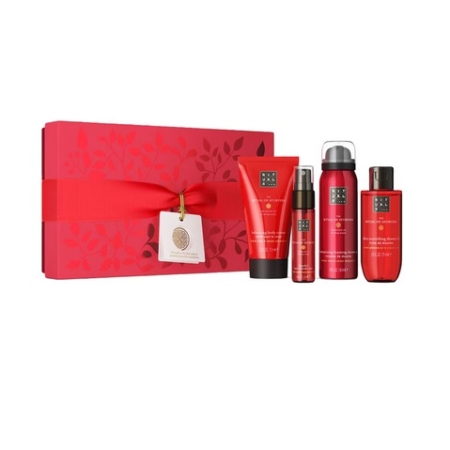 A Rituals The Ritual of Ayurveda Coffret cadeau - une boîte cadeau rouge avec étiquette et ruban assortis - à côté de quatre produits de soin : un tube, un vaporisateur et deux flacons, tous ornés d'élégants motifs floraux. Dakar