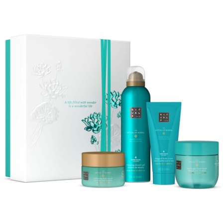 Un ensemble de quatre produits de soins corporels Rituals Coffret Moyen Le Rituel du Karma en sarcelle et or, présentés dans un coffret cadeau floral blanc rehaussé de sarcelle. Le texte de la boîte est le suivant : "Une vie remplie d'émerveillement est une vie merveilleuse. Dakar