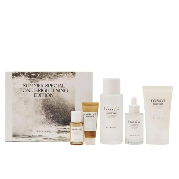 Cinq produits Skin1004 Coffret Édition Spécial Éclaircissant Visage - flacons, compte-gouttes et tubes dans des tons neutres - sont disposés devant une boîte "Summer Special Tone Brightening Edition". Dakar