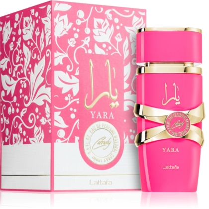 Un flacon rose de Lattafa Yara Candy Eau de Parfum pour femme 100 ml avec des accents dorés est présenté à côté de sa boîte rose et blanche ornée assortie présentant des motifs floraux et une écriture arabe. Dakar