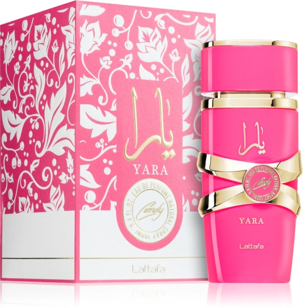 Un flacon rose de Lattafa Yara Candy Eau de Parfum pour femme 100 ml avec des accents dorés est présenté à côté de sa boîte rose et blanche ornée assortie présentant des motifs floraux et une écriture arabe. Dakar