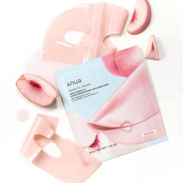 Une présentation à plat de Anua Masque Collagène Éclaircissant à la Peach et à la Niacine 4 pièces, avec des masques roses, des tranches de pêche et l'emballage du produit sur un fond blanc. Dakar