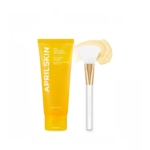 Un tube jaune étiqueté "AprilSkin Masque Peel Off au Calendula Exfoliant Doux Anti Imperfections 100g" est placé à côté d'une brosse blanche et dorée dont les poils sont recouverts de crème, le tout sur fond blanc. Dakar