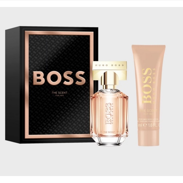 Un cadeau Hugo Boss The Scent for Her Coffret, comprenant un flacon de parfum rectangulaire avec un bouchon doré et un tube de lotion pour le corps assorti de couleur pêche, présentés côte à côte. Dakar