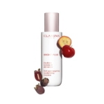Un flacon d'Emulsion Hydratante Anti Taches Bright Plus 75 ml de Clarins est présenté sur un fond blanc, accompagné de tranches de mangoustan et de morceaux de pomme rouge. Dakar