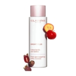 Un flacon blanc de l'essence lactée Clarins Bright Plus Dark Spot-Targeting, entouré de fruits tropicaux dont le mangoustan et des fruits de type cerise, sur un fond blanc. Dakar