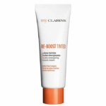 Un tube blanc de My Clarins Re Boost Matte Crème Hydra Matifiante Peaux Mixtes à Grasses 50ml, avec un texte orange et noir sur le devant, se tient debout sur un fond blanc. Dakar
