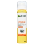 Une boîte de 75 ml de Garnier Skin Active Spray SPF50 de Maquillage Glowy UV Vitamine C, décrit comme invisible, végétalien et idéal pour un usage quotidien. L'emballage est principalement blanc et jaune, avec les détails du produit sur le devant. Dakar