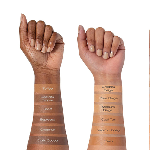 Deux avant-bras présentent les teintes de L.A. Girl Anti Cernes et Correcteur 8 g : le bras gauche présente des teintes plus profondes (Toffee à Dark Cocoa), tandis que le bras droit présente des teintes plus claires (Creamy Beige à Fawn) avec des échantillons étiquetés sur la peau. Dakar