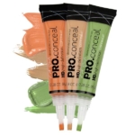 Trois tubes de L.A. Girl Anti Cernes et Correcteur 8 g dans les tons orange, beige et vert, chacun présenté avec les échantillons correspondants derrière les tubes. Dakar