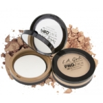 Trois poudres compactes L.A Girl Poudre Ultra Fine et Fini Mat Pro Face Matte Pressed Powder 7 g ouvertes, chacune avec un miroir et une éponge d'application, présentées sur un fond de poudre libre éparpillée. Dakar