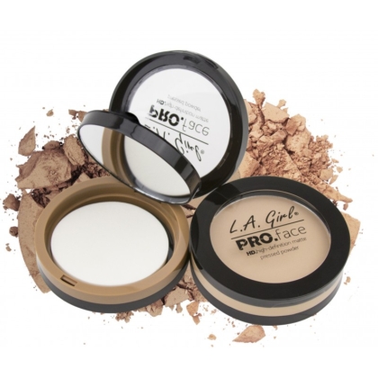 Trois poudres compactes L.A Girl Poudre Ultra Fine et Fini Mat Pro Face Matte Pressed Powder 7 g ouvertes, chacune avec un miroir et une éponge d'application, présentées sur un fond de poudre libre éparpillée. Dakar