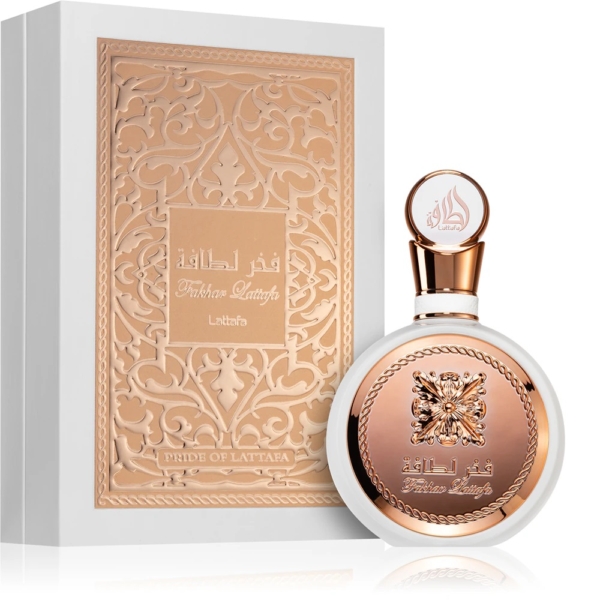 Un flacon de parfum rond au design or rose et blanc est placé devant une boîte ornée d'écritures arabes, tous deux étiquetés "Lattafa Yara Candy Eau de Parfum pour femme 100ml (Copie)"-exemptant d'élégance et de style. Dakar