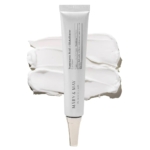 Un tube de Mary and May Crème Contour Yeux à l'Acide Tranexamique et au Glutathion 30 g repose sur trois échantillons de crème blanche, montrant la texture. Le tube est blanc, épuré, et comporte un texte gris minimaliste. Dakar