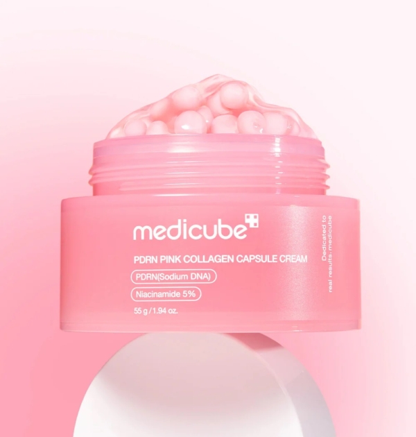 Un pot rose de Medicube PDRN Pink Collagène Capsule Crème Éclat Effet Glass Skin 55 ml, avec des capsules roses visibles et étiquetées avec PDRN (Sodium DNA) et 5% Niacinamide, sur un fond rose clair. Dakar
