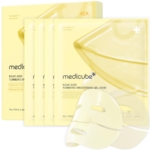 Quatre sachets de Masque Gel Éclaircissant à l'Acide Kojique et au Curcuma 1 Pièce sont présentés, avec un masque gel translucide devant. L'emballage jaune met en évidence les principales caractéristiques du produit et une teneur en niacinamide de 2 %. Dakar