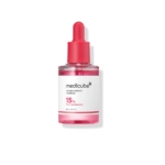 Un flacon compte-gouttes en verre transparent de Medicube TXA+Niacinamide 15% Sérum Correcteur de Tâches 30 ml avec un bouchon et une étiquette rouges, indiquant "15% TXA + Niacinamide" sur le devant. Dakar