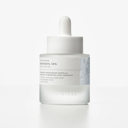 Un flacon compte-gouttes en verre givré étiqueté "Skin1004 Sérum Ampoule Raffermissant au Matrixyl Centella et Hyaluron Peau Rajeunie 30 ml", avec un bouchon et un compte-gouttes blancs, contenant un sérum de soin pour la peau, sur un fond blanc uni. Dakar