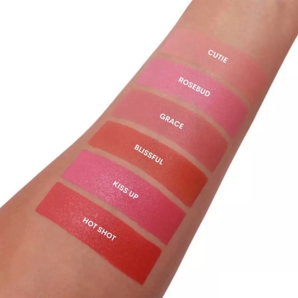 Un bras montre six échantillons de L.A Girl Blush Lèvres et Joues Soft Matte Cream Blush 8 ml, étiquetés de haut en bas : Cutie, Rosebud, Grace, Blissful, Kiss Up et Hot Shot dans des teintes roses, corail et rouges. Dakar
