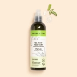 Un flacon de 250 ml d'Aroma Zone Gel natif d'Aloe Vera BIO avec une étiquette verte se tient debout sur un fond beige, à côté de deux gouttes de gel et de deux feuilles d'aloès vertes. Dakar