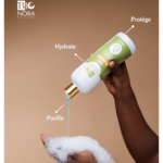 Une main verse le gel bleu d'un flacon de 500 ml de Bionora Gel Douche SPF15 Gommant Éclaircissant Anti Taches Visage et Corps sur une paume savonneuse. Des flèches soulignent les mots "Hydrate", "Purifie" et "Protège" sur l'étiquette. Dakar
