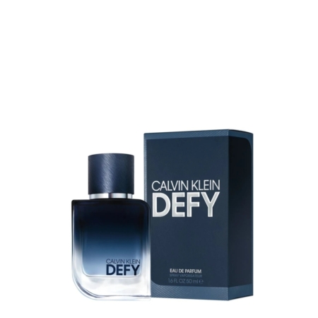 Un flacon de Calvin Klein Men's Defy Eau de Parfum 50 ml est présenté à côté de sa boîte bleue, tous deux avec des lettres blanches en gras. Le flacon de parfum présente un dégradé allant du bleu foncé en haut au transparent à la base. Dakar