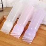 Le Dreamfix Applicateur de Bain Huile et Teinture Capillaire comprend trois flacons translucides (blanc, rose, violet) avec des embouts peigne intégrés pour une application facile de la teinture ou de l'huile, présentés sur un plateau en bois. Dakar
