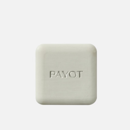 Savon Payot Savon Nettoyant Purifiant Anti Imperfections Visage et Corps 65 g, de forme carrée et de couleur blanc cassé, aux bords arrondis et portant l'inscription "PAYOT" en relief sur le devant, sur fond blanc uni. Dakar