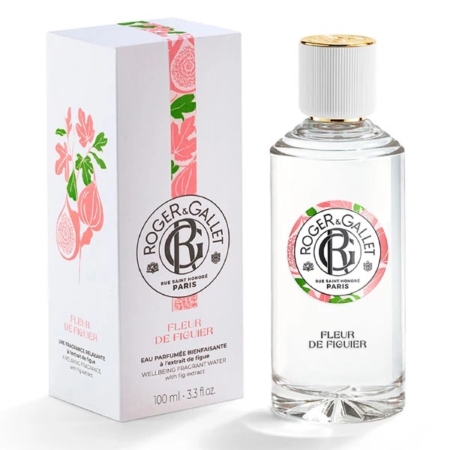 Un flacon du parfum Roger & Gallet Fleur de Figuier se trouve à côté de sa boîte blanche décorative, qui comporte des illustrations de fleurs roses et de figues. Le flacon a un corps transparent, un bouchon doré et une étiquette assortie au design du coffret. Dakar