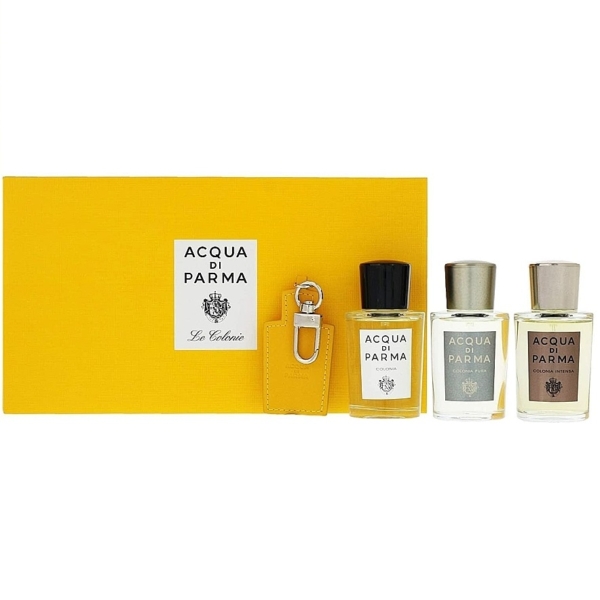 Un coffret cadeau Acqua di Parma jaune avec une étiquette blanche apparaît à côté de trois petits flacons de parfum et d'un porte-clés en cuir jaune de la collection Acqua Di Parma Le Colonie Coffret 5 Produits pour Homme. Dakar