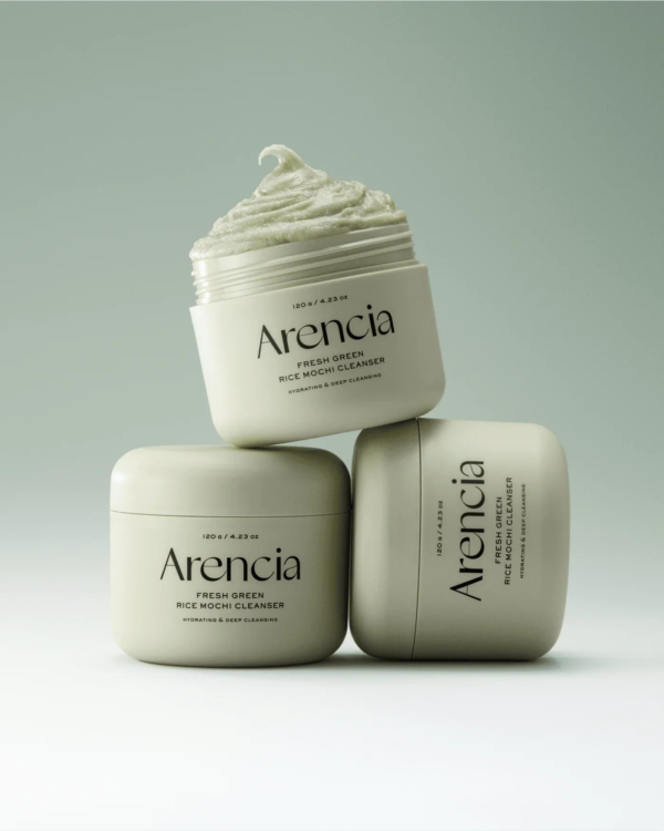 Trois pots de Arencia Fresh Green Nettoyant Visage Mochi au Riz Vert 120 g sont empilés dans un style minimaliste. L'un des pots est ouvert, montrant sa texture fouettée et crémeuse à l'intérieur, tandis que les deux autres restent fermés. Dakar